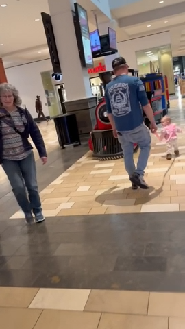 Parent et enfant dans un centre commercial avec le sac à dos BambinSafe